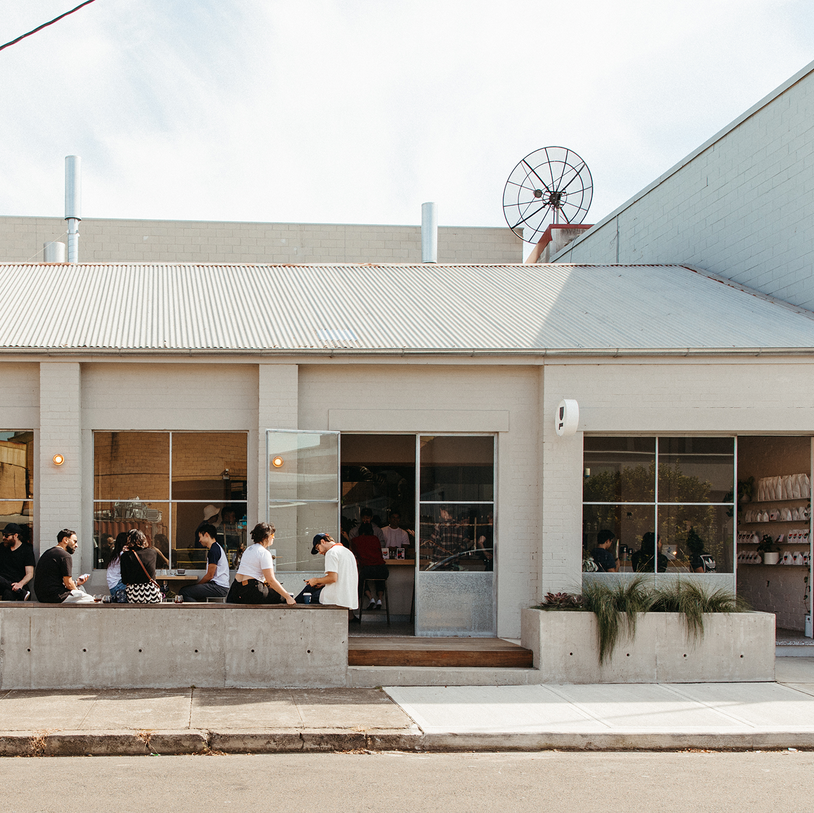 People sitting outside a modern building with large windows