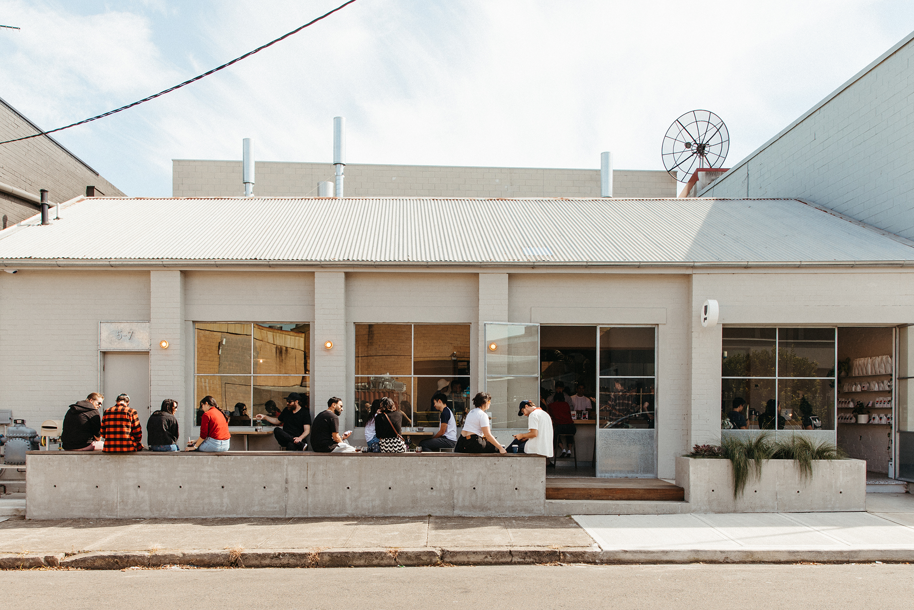 People sitting outside a Deluca Coffee in Marrickville.
